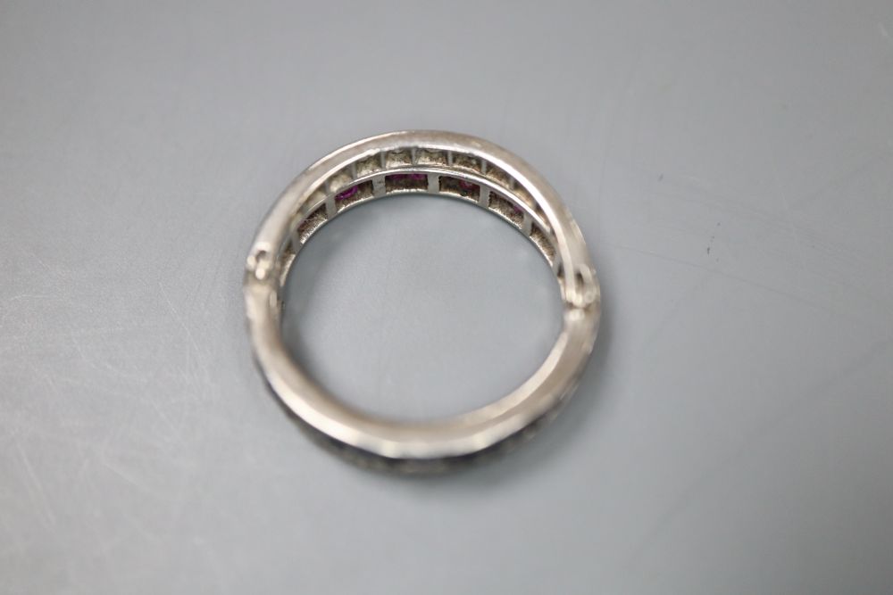 A white metal, diamond, ruby and sapphire swivelling eternity ring (ruby missing), size K, gross 5 grams.